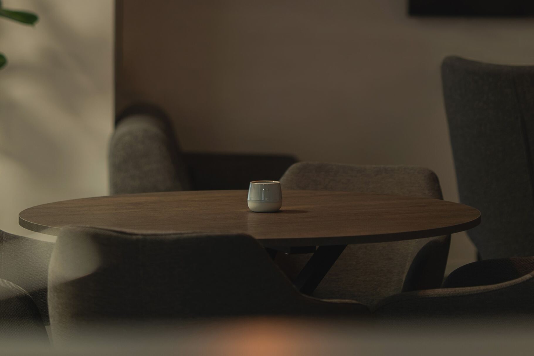 Kontakta oss. Mörkt träbord med ljushållare i mitten i dämpad belysning