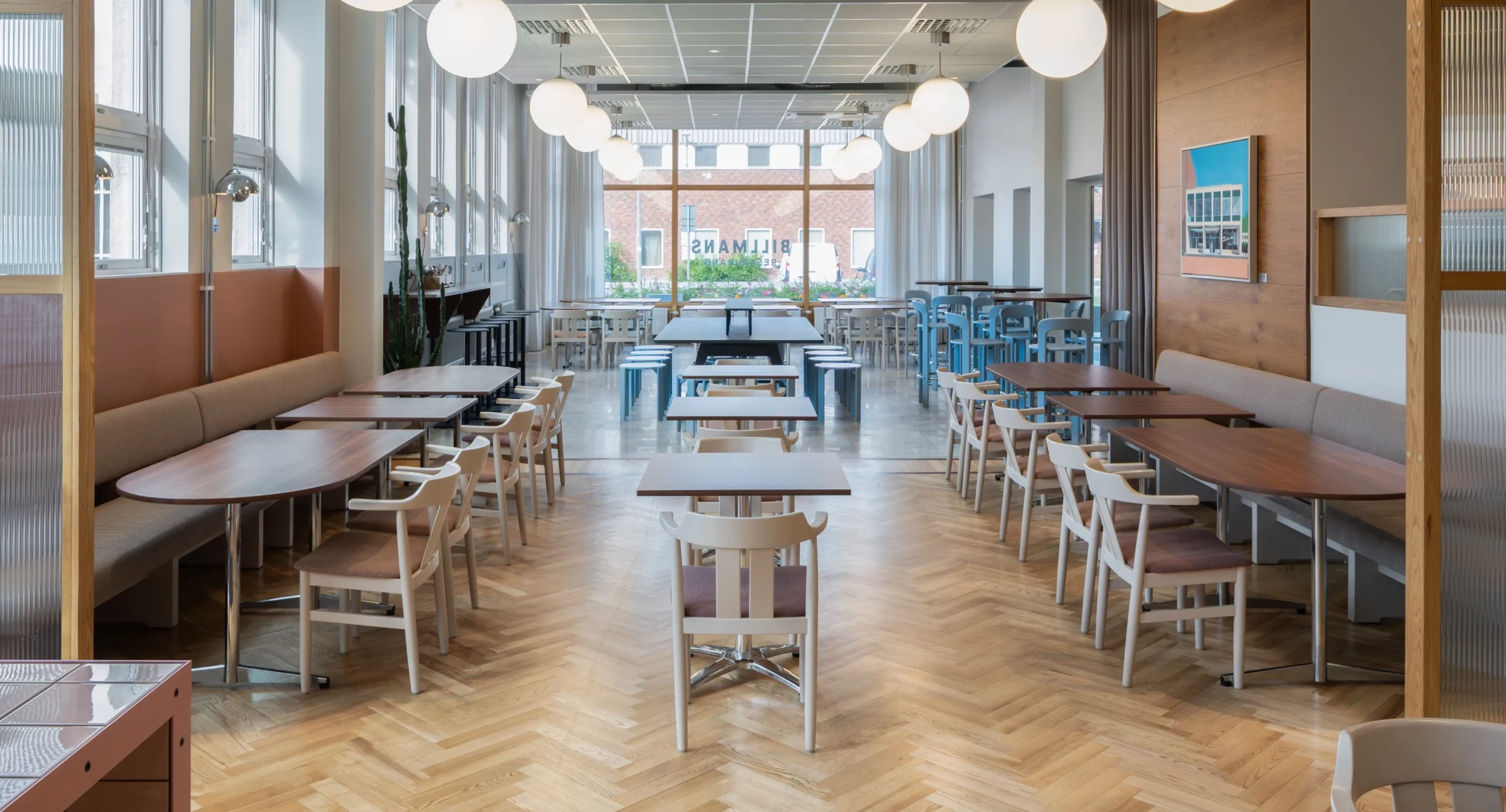 Bild från restaurangmiljö med fint ljusinsläpp och rader av stolar och bord