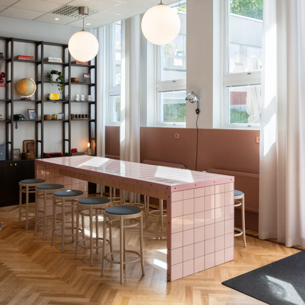 Sittyta med puderrosa kakel och naturligt ljusinsläpp